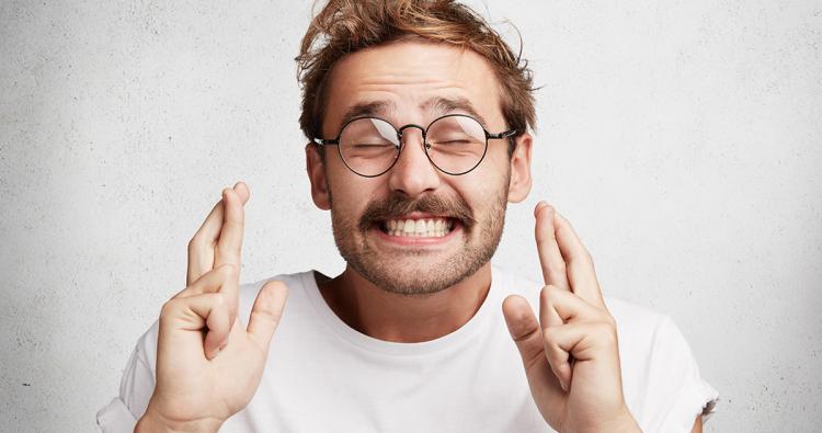 Mann mit Brille kreuzt Finger