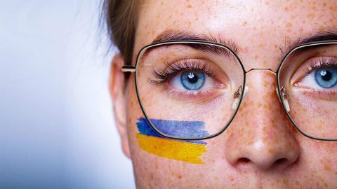 Brillenträgerin mit Ukraine-Flagge im Gesicht