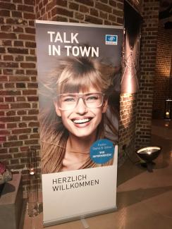 Das Bild zeigt eine Ankündigung zu Essilors Veranstaltung in Köln: "Talk in Town"