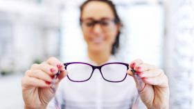 Augenoptikern hält eine Brille