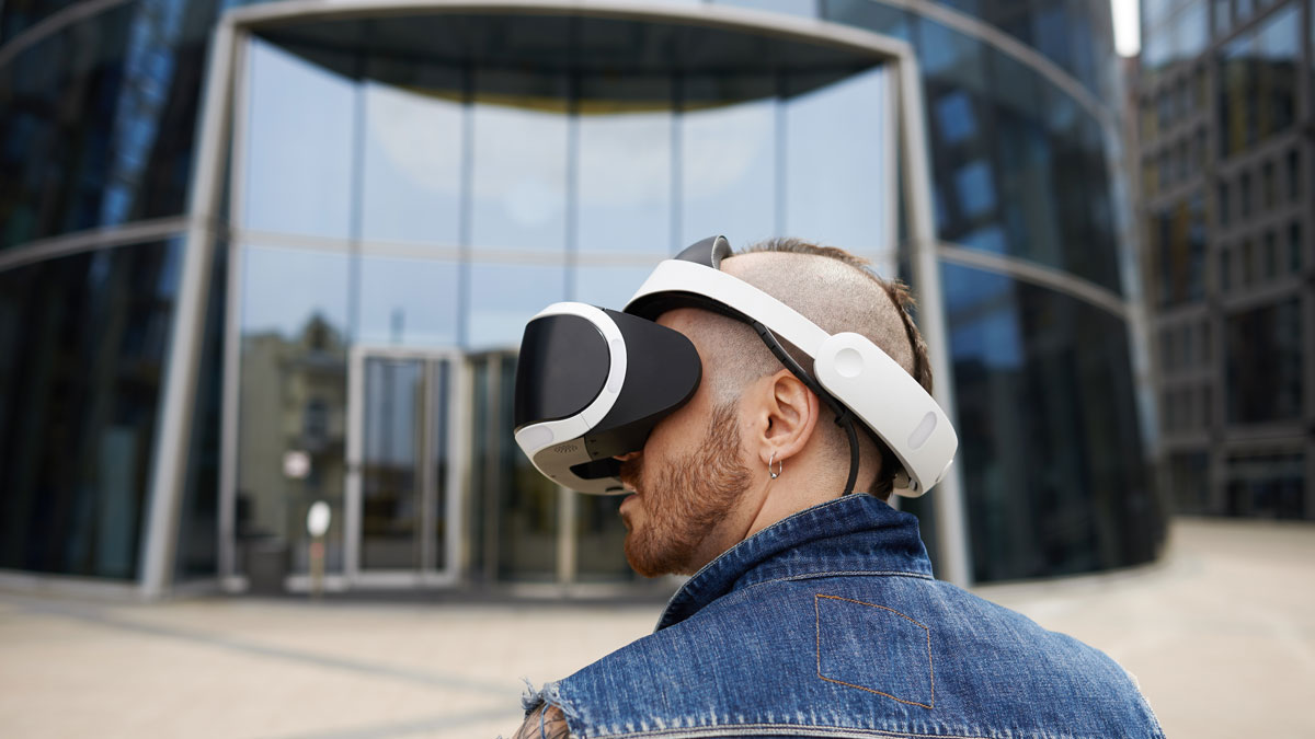 Mann mit VR Brille vor Glasgebäude