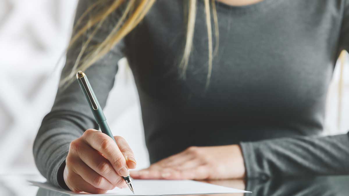 Frau schreibt auf Papier