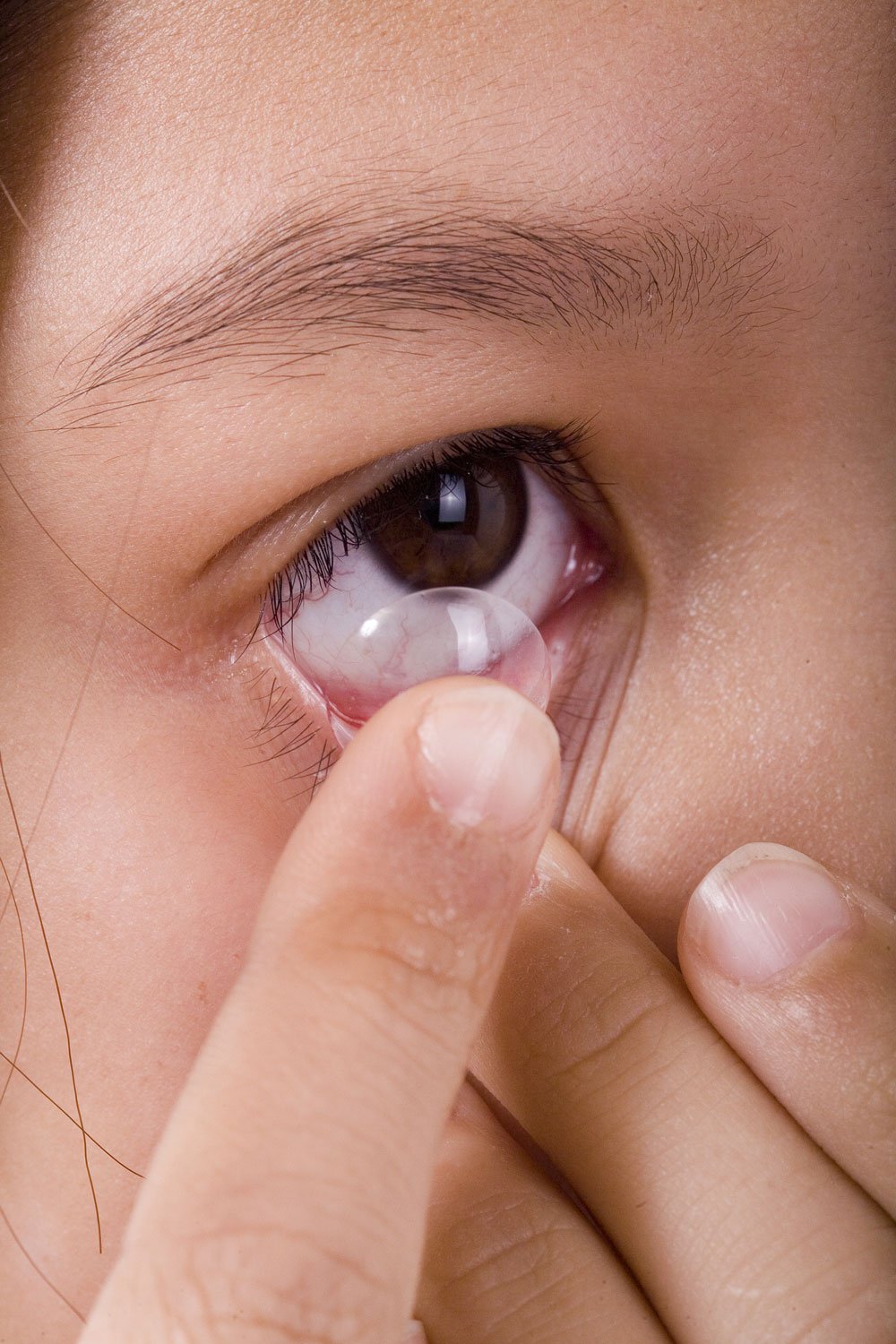 Junges Mädchen setzt Kontaktlinse ein