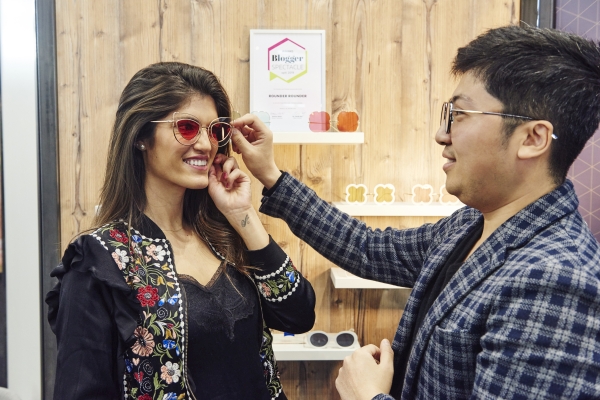 opti Aussteller präsentiert Brillen einer Kundin