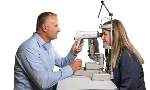 Augenoptiker prüft Kundin mit der SIGNAL-Netzhautkamera