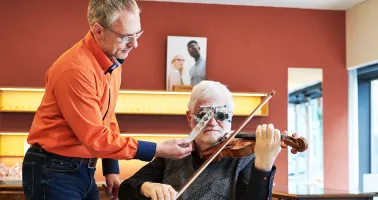 Optiker mit Kunde an der Geige