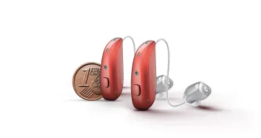 Hörgerät verglichen mit einer Centmünze