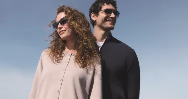 Eine Frau und ein Mann mit Sonnenbrille vor blauem Himmel