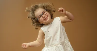 kleines fröhliches Mädchen mit Brille