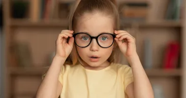 Kind hält Brille auf der Nase