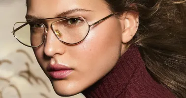 blonde Frau mit Korrektionsbrille und roten Rollkragenpullover