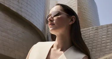 Frau mit Sonnenbrille sitzt vor Guggenheim-Museum