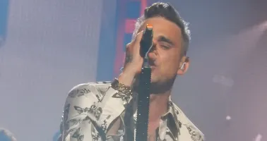 Robbie Williams singt in ein Mikrofon