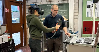 Frau mit KI-Brille und Mann am PC