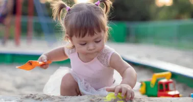 Kind spielt im Sand