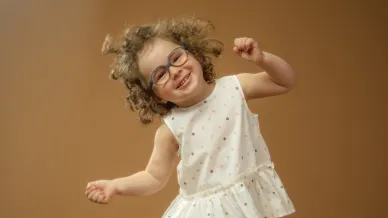 kleines fröhliches Mädchen mit Brille