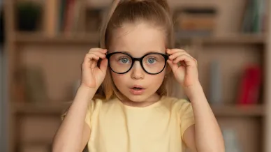 Kind hält Brille auf der Nase