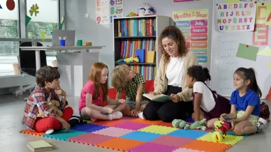 Frau sitzt mit Gruppe Kinder zusammen