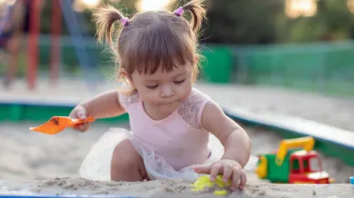 Kind spielt im Sand