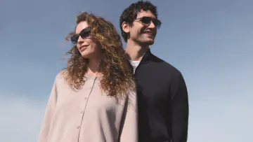 Eine Frau und ein Mann mit Sonnenbrille vor blauem Himmel