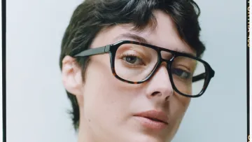 Frau mit kurzen braunen Haaren und Acetatbrille