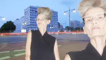 ältere Dame mit markanter Brille und Frisur steht in Berlin auf der Straße