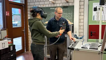 Frau mit KI-Brille und Mann am PC