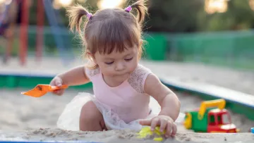 Kind spielt im Sand