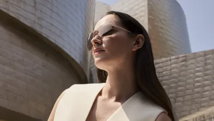 Frau mit Sonnenbrille sitzt vor Guggenheim-Museum