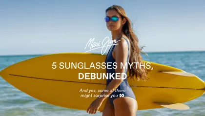 Frau am Meer mit gelbem Surfbrett und Sonnenbrille