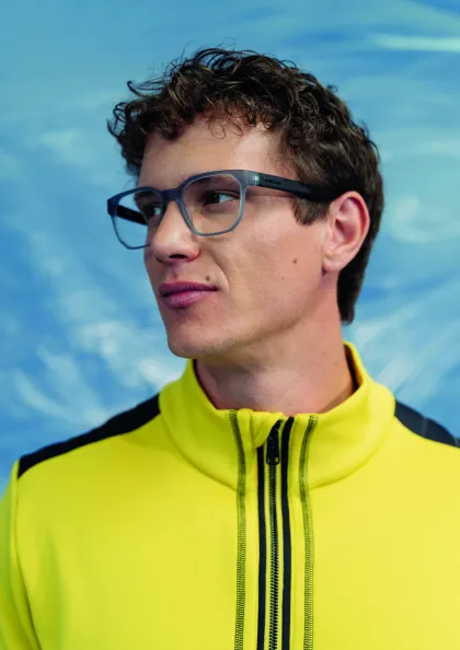 Mann mit Korrekturbrille und gelben Sportshirt