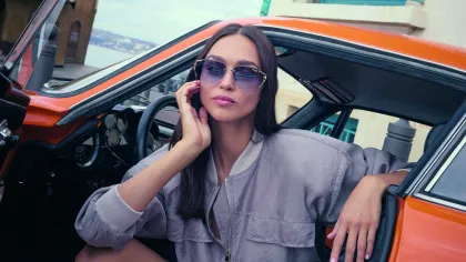 Frau mit Sonnenbrille sitzt im Auto 