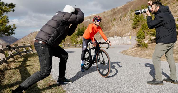 Fahrradfahrer mit Sportbrille und Fotografen