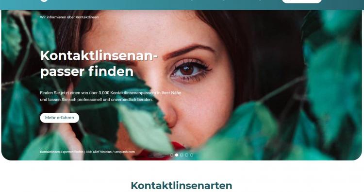 Eine Frau blickt verträumt durch Blätter, als Homepagehintergrund des Unternehmens