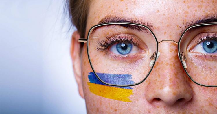 Brillenträgerin mit Ukraine-Flagge im Gesicht
