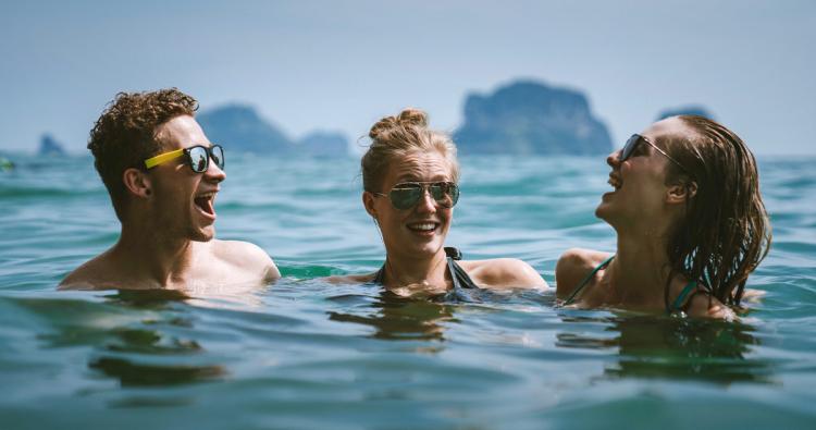 Junge Menschen im Sommer im Meer mit Sonnenbrille