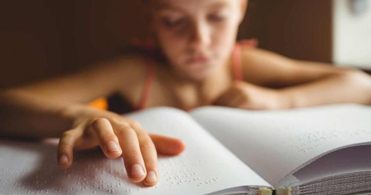 Kind ließt Blindenschrift Buch