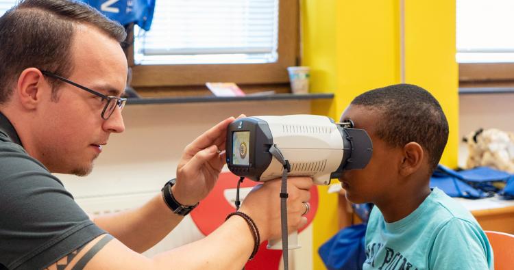 Augenoptiker untersucht ein Kind