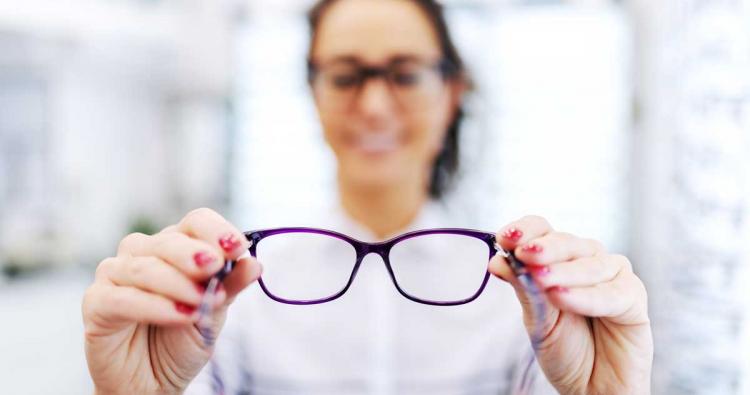 Augenoptikern hält eine Brille