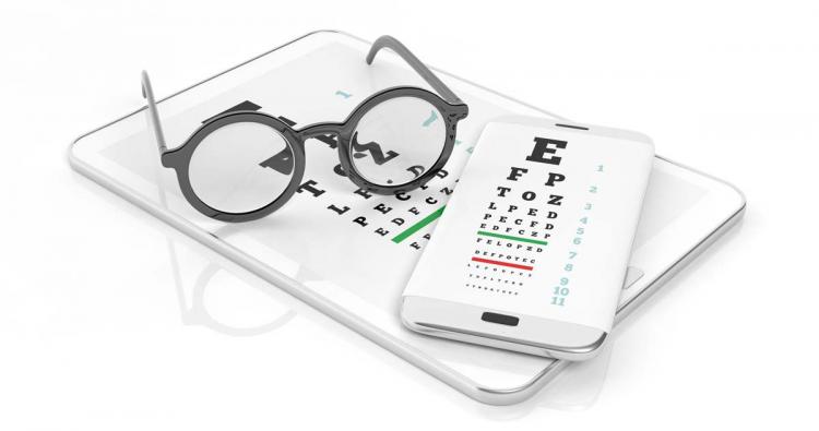 brille liegt auf Tablet bereit für Online Sehtest