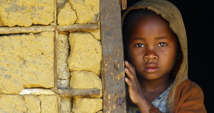Kind aus Afrika blickt schüchtern in die Kamera