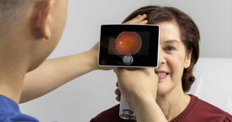 Augenoptiker untersucht Kundin mit SIGNAL-Netzhautkamera