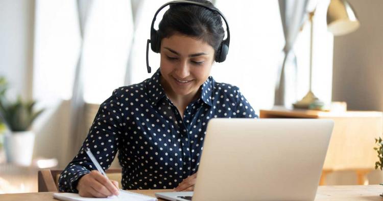 Mädchen mit Headset lernt am Laptop online
