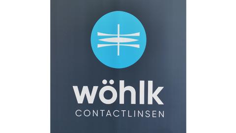 Das Logo von Wöhlk, ein blauer Kreis mit zwei konkaven Rohlingen im Profil und einem konvexen in der Mitte