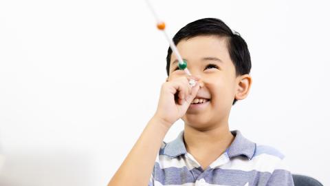 Ein Kind beim Fokussieren von Perlen in unterschiedlichen Abständen