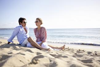 Mann und Frau mit Sonnenbrille am Strand
