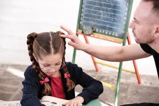 Mädchen mit Brille liest ein Buch, Fotograf richtet ihre Haare
