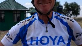 Der von Hoya gesponserte Teilnehmer Roland Moor mit Videokamera auf dem Helm und Fahrradkluft in Afrika unterwegs. 